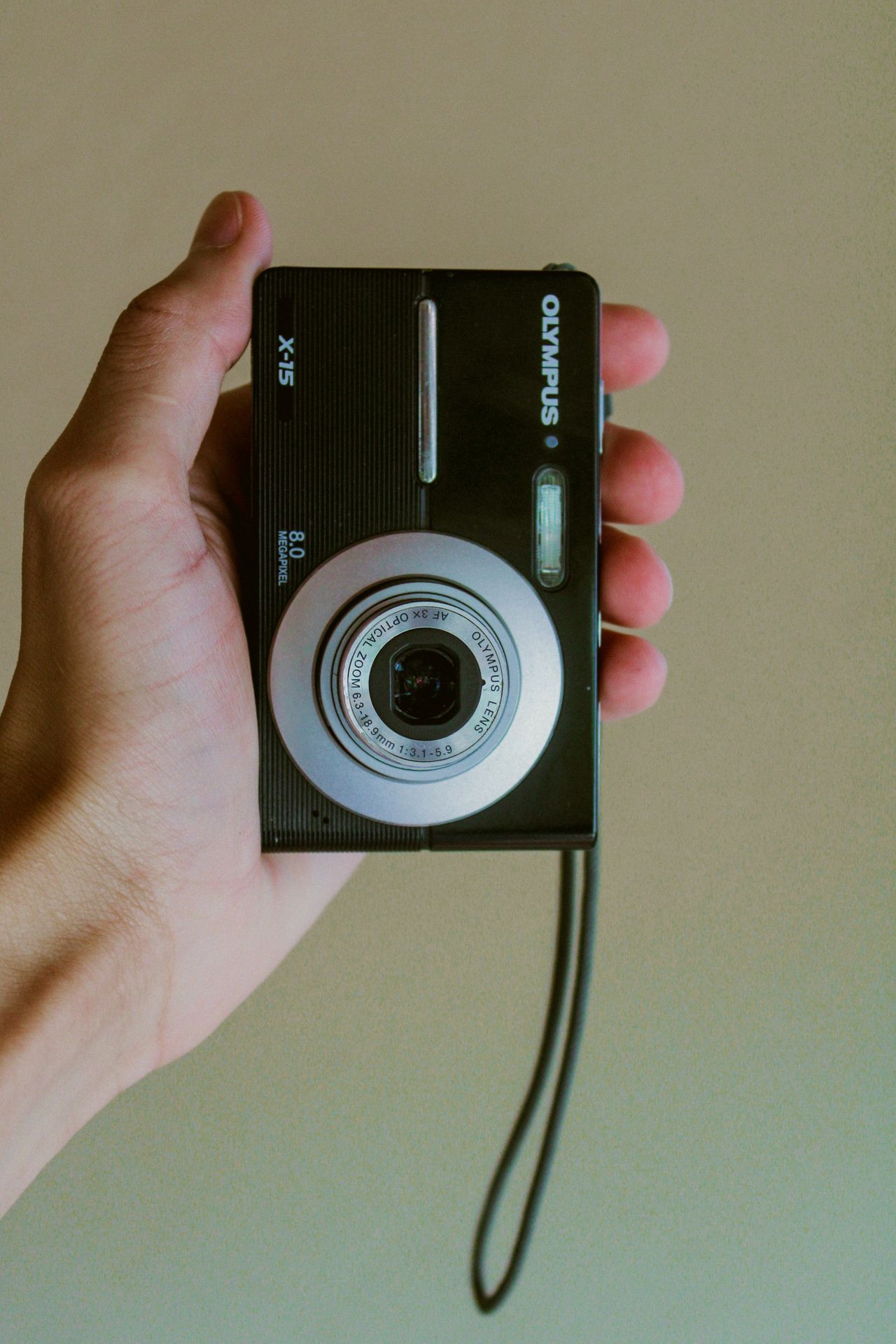 person holding black and gray Olympus point-and-shoot camera
